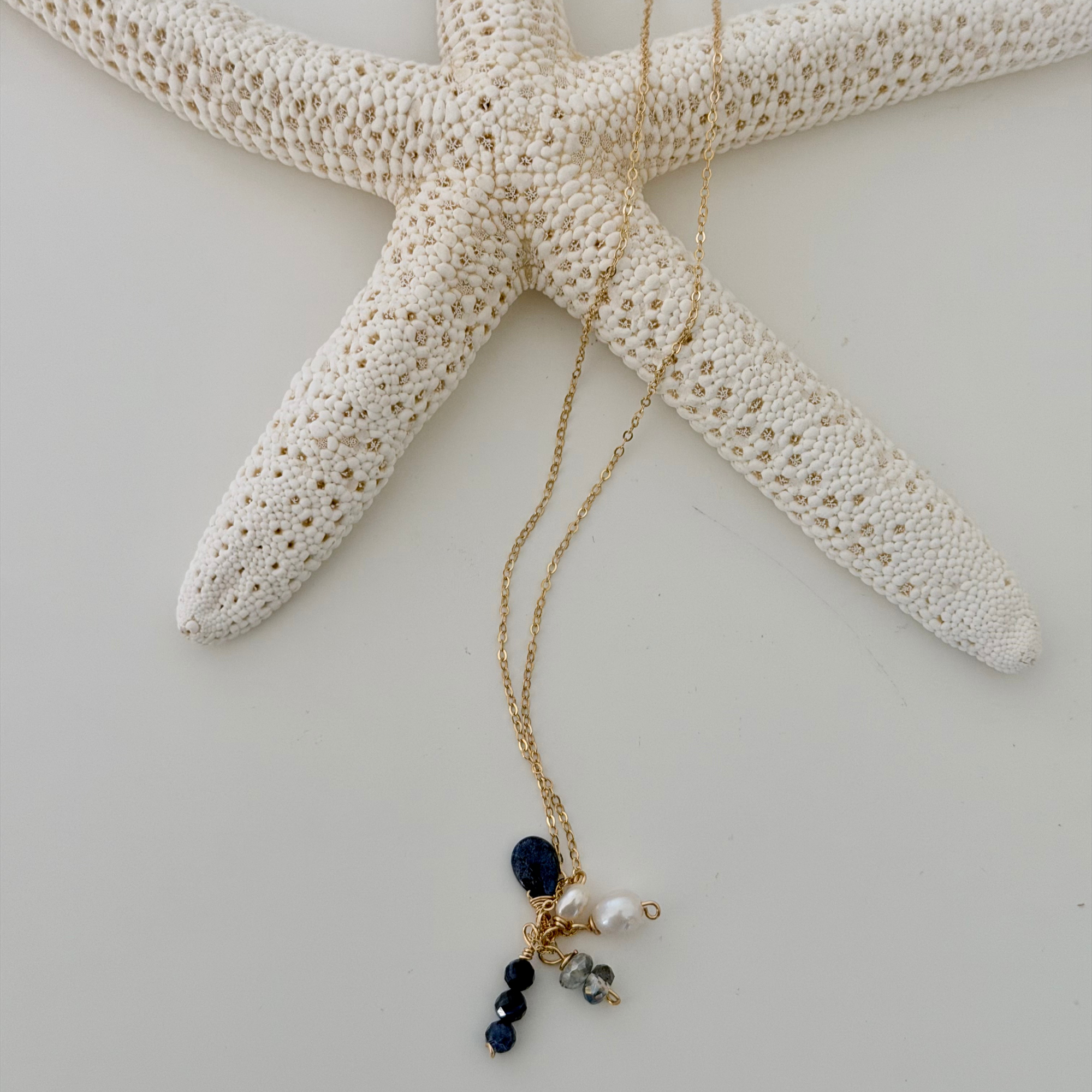 Gold necklace with blue and white beads on a starfish
