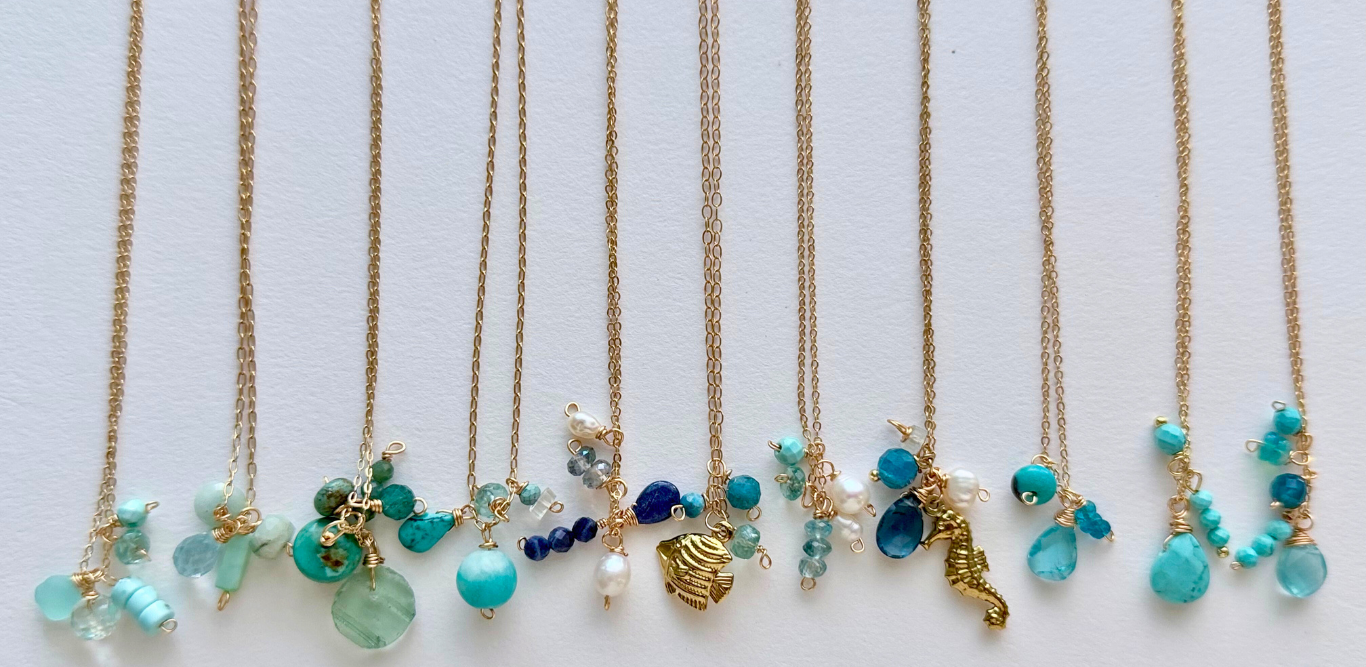 Set of gold necklaces with turquoise and blue beads on a white background